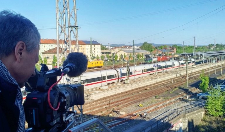 Kameramann nimmt Zug in Bahnhof auf